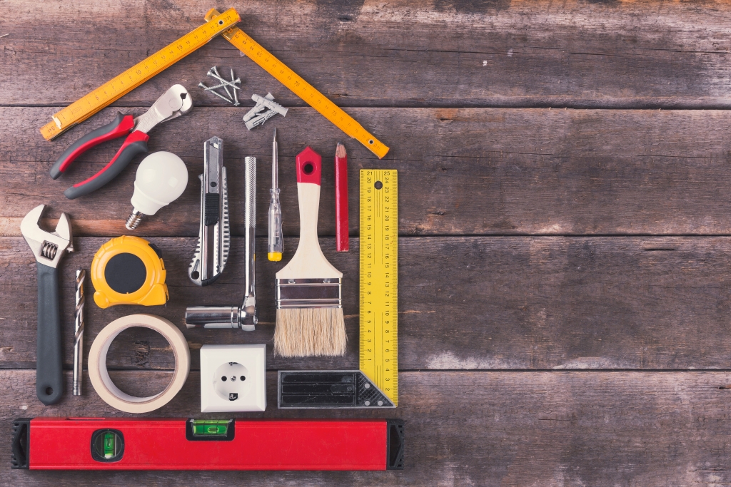 Tools in the shape of a house on a wood background