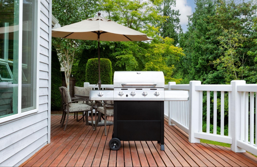 Deck with grill, table, and umbrella