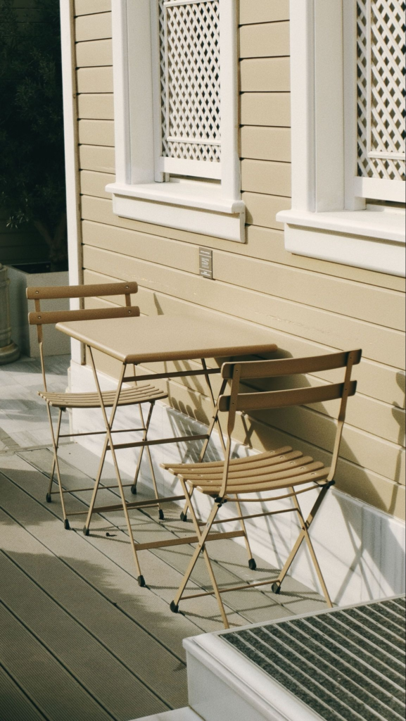 Two chairs surrounding small table on deck